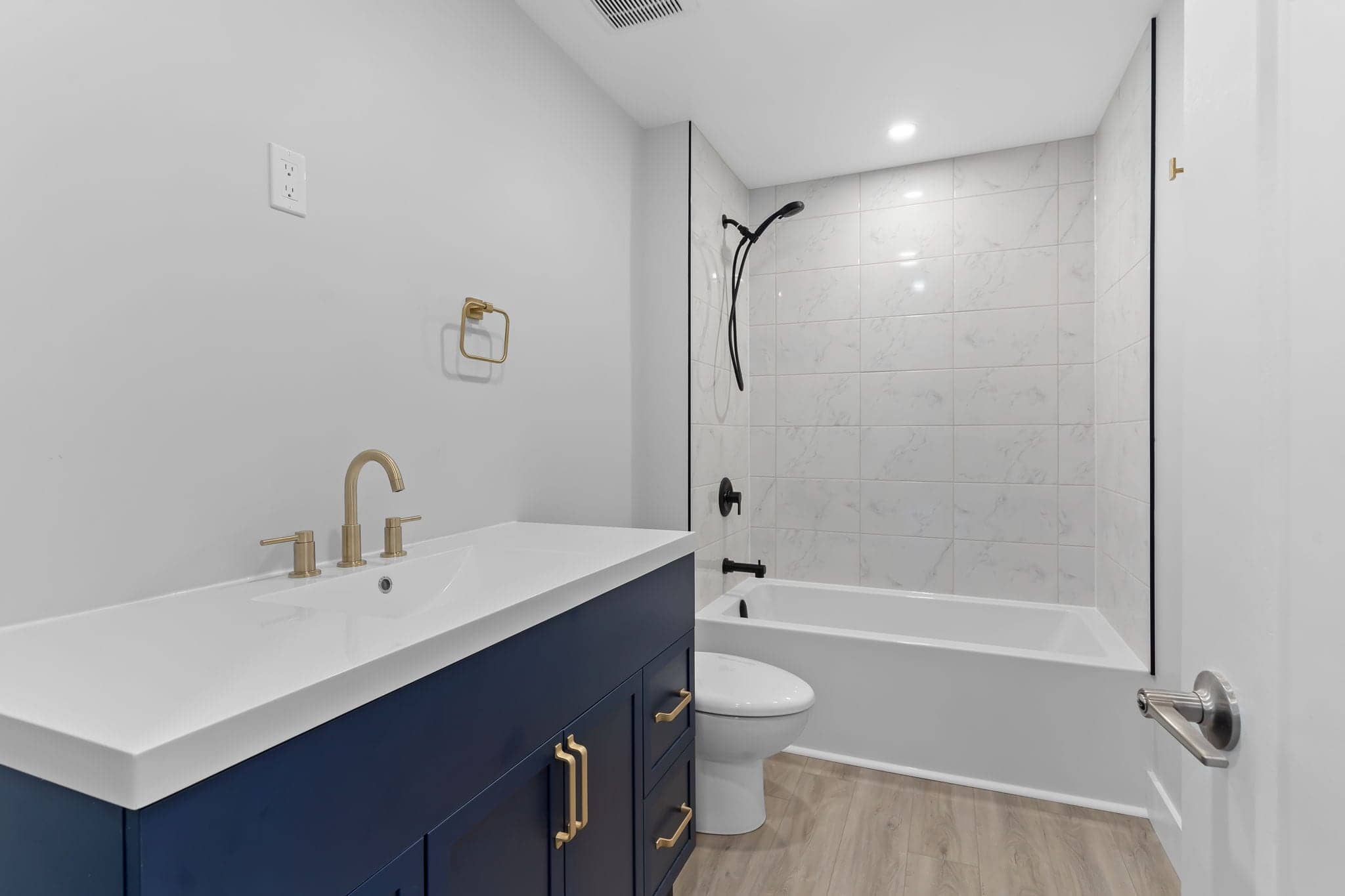A clean white-and-navy bathroom renovation by Redden's Contracting.