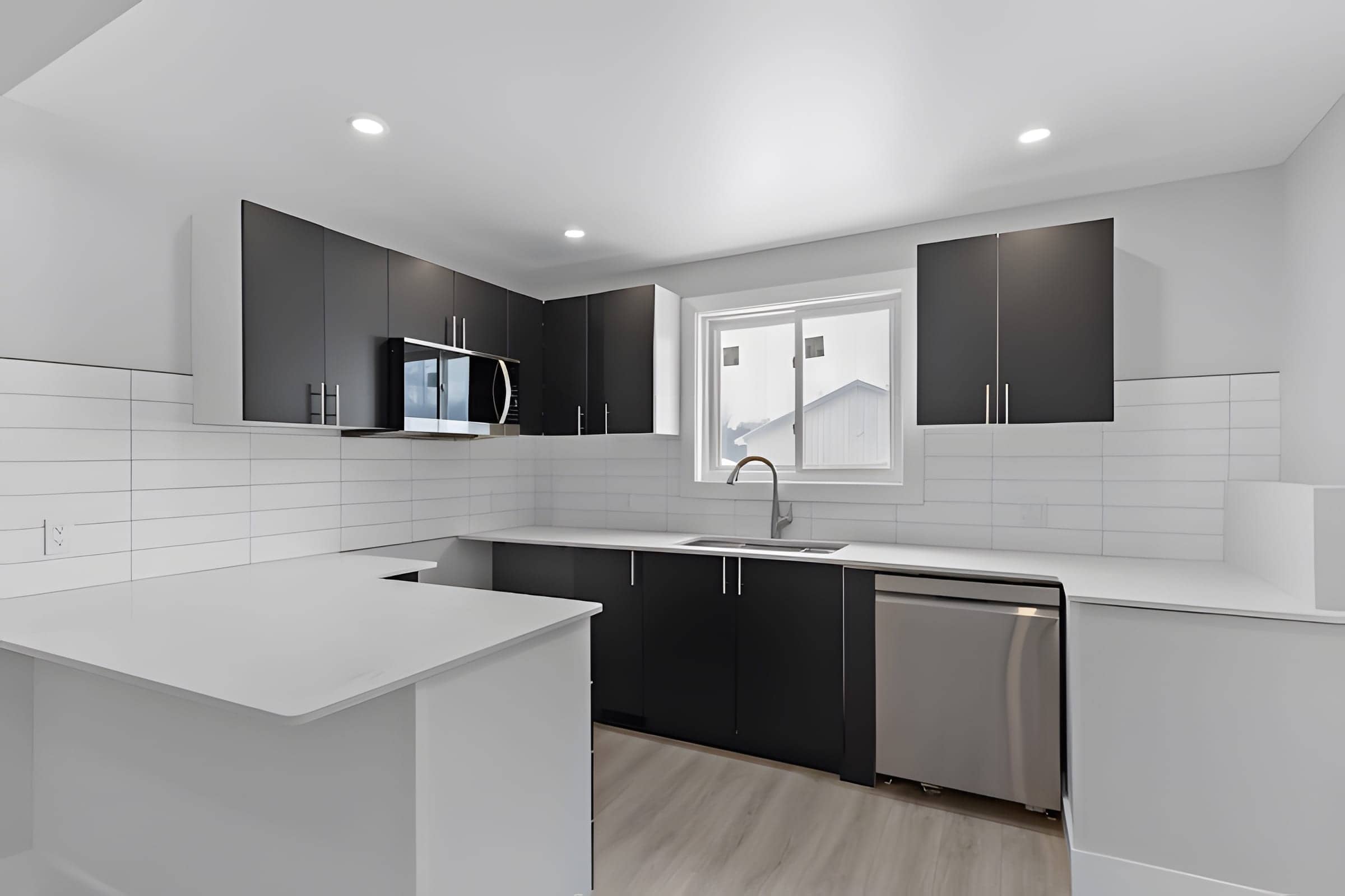 Modern two-tone kitchen with dark uppers and quartz counters